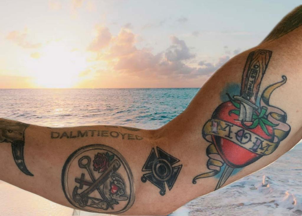 A person with tattoos on their arm at the beach