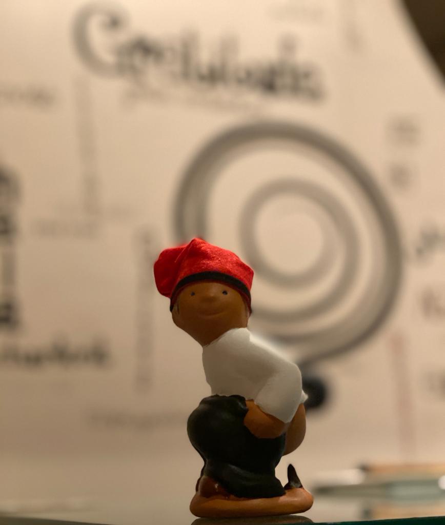 A toy baseball player is in front of a spiral background.