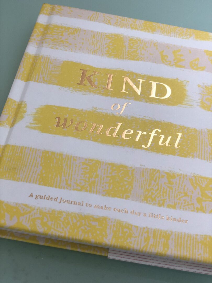 A yellow and white book with the words kind of wonderful on it.