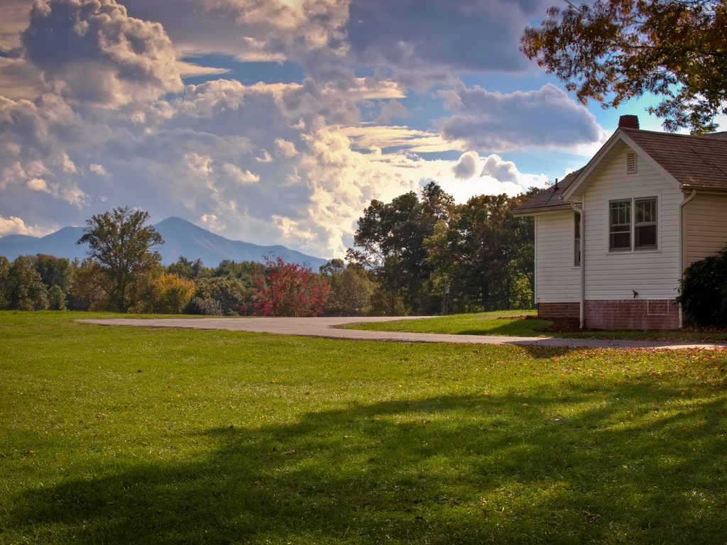 A house sitting on top of a lush green hillside.